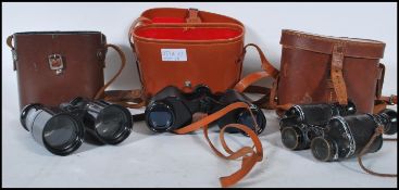 Three pairs of vintage 20th Century cased binoculars to include a leather cased military style pair,