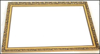 A 20th Century large overmantle framed wall mirror, the ornate gilt Art Nouveau style decorated in
