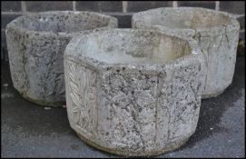 A collection of three well weathered octagonal reconstituted garden planters, each side moulded in
