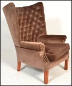 A good quality 20th century large wingback armchair raised on squared legs with stretchers. Above