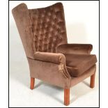 A good quality 20th century large wingback armchair raised on squared legs with stretchers. Above