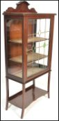 An early 20th Century Edwardian string inlaid mahogany display cabinet with gallery scroll top,