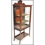 An early 20th Century Edwardian string inlaid mahogany display cabinet with gallery scroll top,