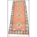 A vintage 20th Century woolen kilim rug having a blue ground with a central red panel with geometric