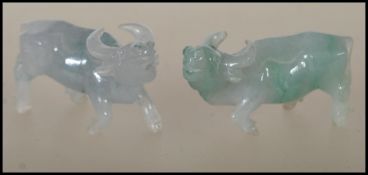 A pair of Chinese jade carved figurines of small proportions in the form of water buffalos. One of