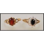 A hallmarked 9ct gold ring set with an oval cut garnet having pierced shoulders in the form of