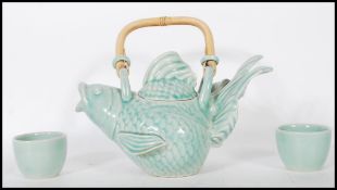 A 20th Century Oriental Chinese teapot in the form of a goldfish having a green glaze and bamboo