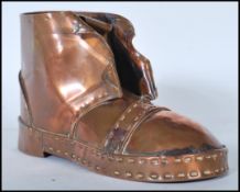 An early 20th Century Arts and Crafts copper hobnail boot having hand beaten decoration. Measures