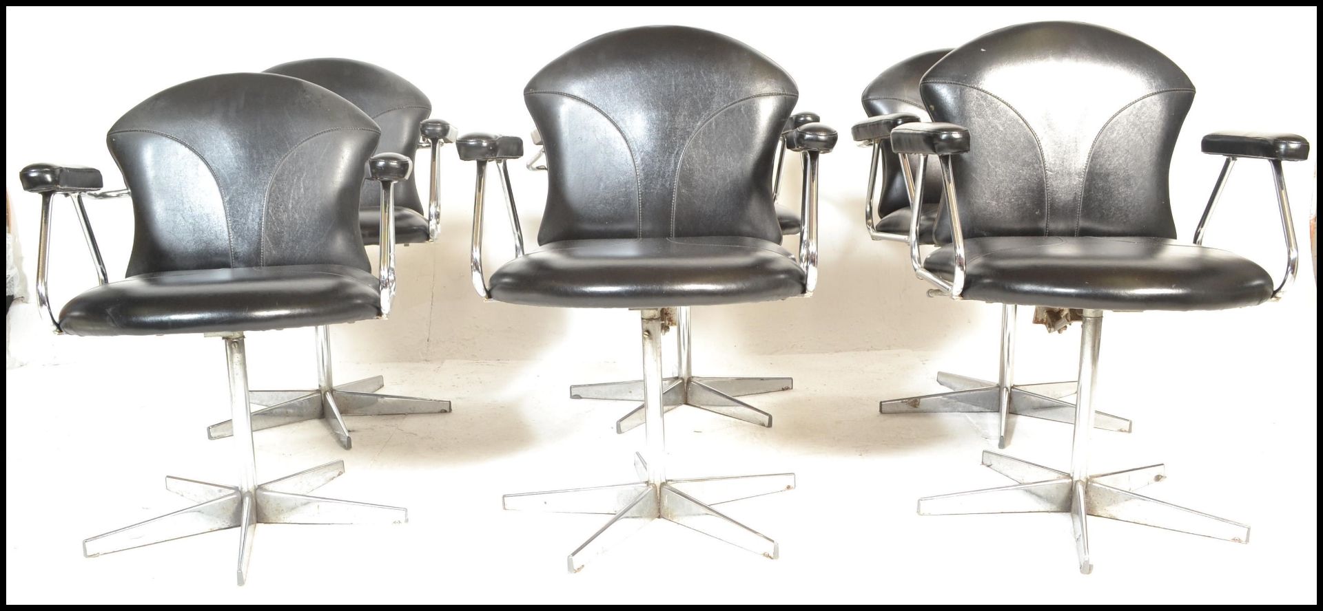 A set of 6 mid century retro chrome and faux black leather swivel chairs - dining chairs having been