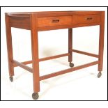 A vintage mid 20th century teak wood butler's tea / drinks trolley having a rectangular top with