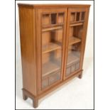 A mid 20th Century glazed oak bookcase, two long glazed doors having adjustable shelves to the