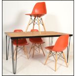 A retro style metal framed plank top dining table raised on hairpin upright supports in a black