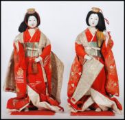 A pair of 20th Century Chinese ornamental dolls depicting two women in traditional dress, having