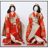 A pair of 20th Century Chinese ornamental dolls depicting two women in traditional dress, having