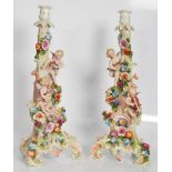 A pair of 19th Century tall cupid candlesticks in the manner of Meissen / Dresden, cupids with