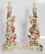 A pair of 19th Century tall cupid candlesticks in the manner of Meissen / Dresden, cupids with