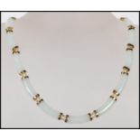 A Chinese jade spacer necklace constructed from 16 curved jade panels mounted on 14ct gold mounts