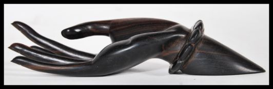 A 20th Century carved wooden ebony ring holder in the form of a hand with elongated fingers and a