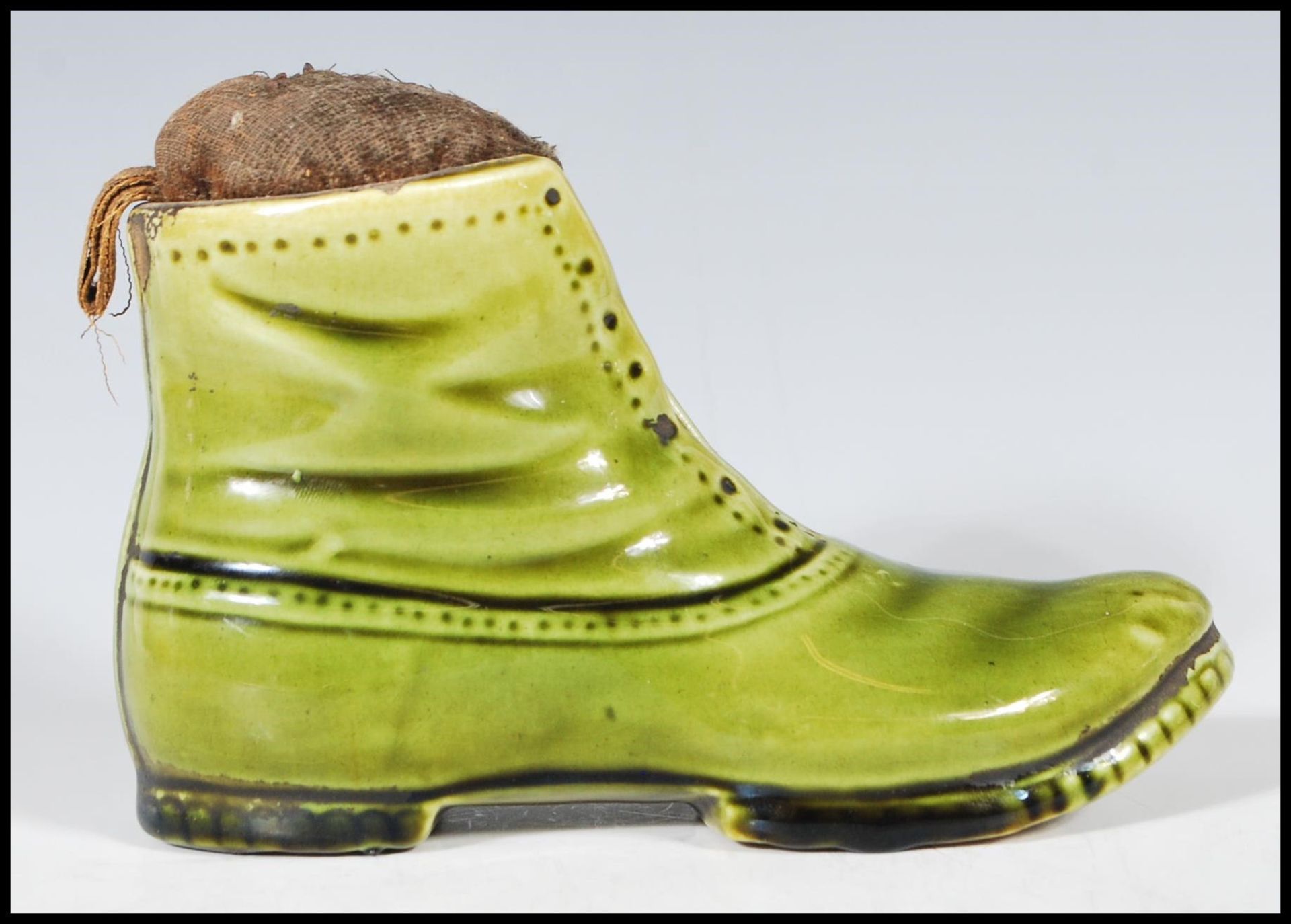 A 19th Century Victorian ceramic pin cushion in the form of boot having a green glaze with a straw - Bild 3 aus 7