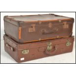 Two vintage 20th Century suitcase trunks to include a brown leather trunk painted with initials W.