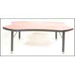 A 20th Century retro coffee table of square form having concave sides to the red top with ebonised