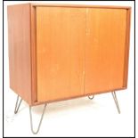 A mid century teak wood and hairpin leg cabinet. Raised on hairpin legs with a double door teak wood