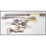 A small group of flatware and other tools to include three toasting forks having silver collars with