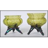 A pair of early 20th Century pressed green glass vases of bulbous forms raised on tripod