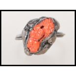 A late 19th / early 20th Century Art Nouveau silver ring set with a coral panel carved with