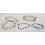A group of five silver bracelets to include a puzzle bracelet, link and panel examples one having