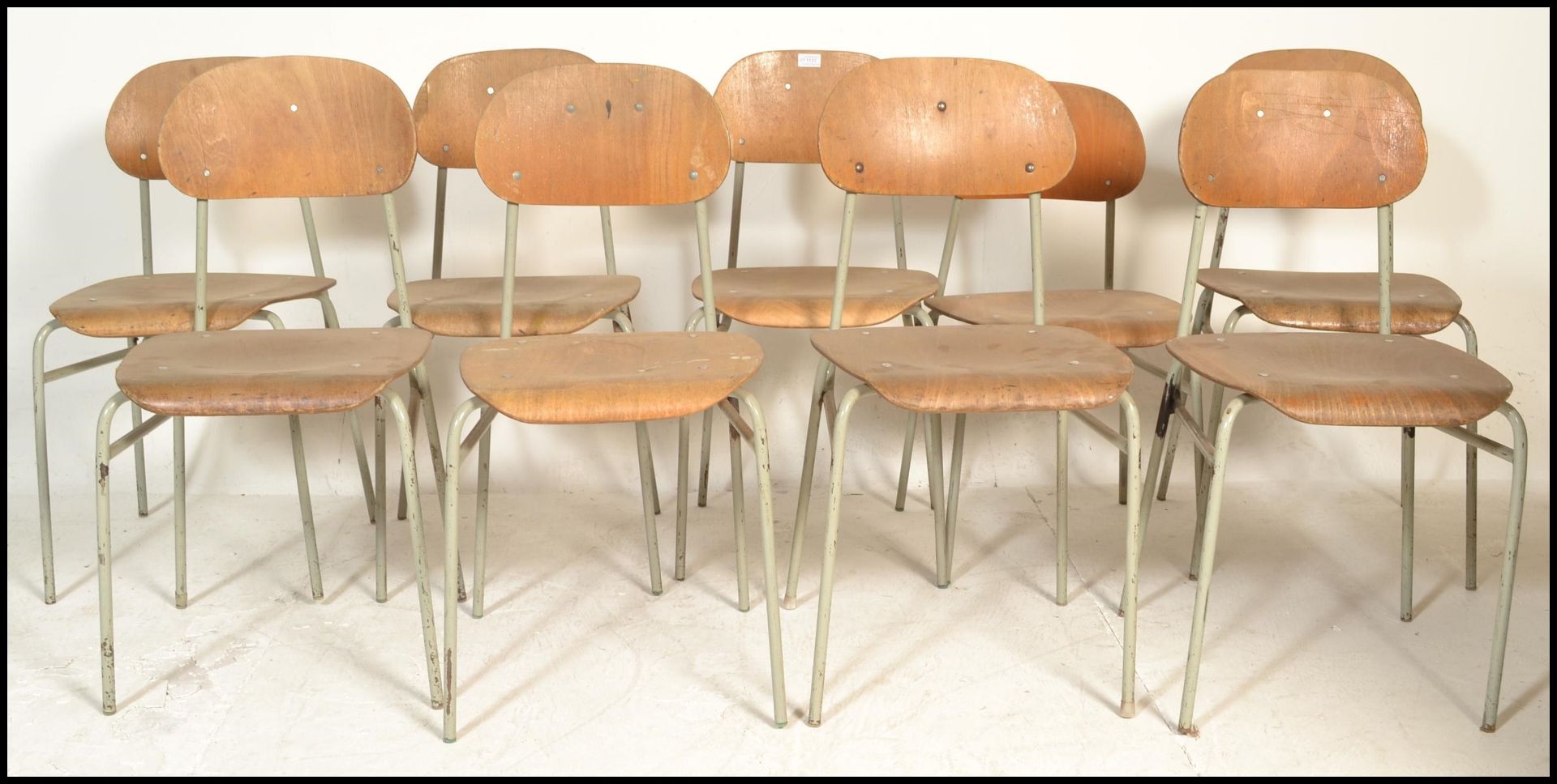 A set of 9 mid 20th century bentwood and tubular metal industrial stacking chairs. Each with painted