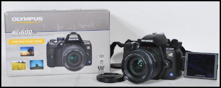 An Olympus E-600 digital camera with Zuiko ED 14-42mm lens complete in the box with shoulder strap