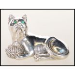 A stamped 925 sterling silver figure of a seated cat playing with a ball of wool set with green