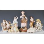 A collection of 20th Century German ceramic figurines to include two Sitzendorf figure groups