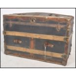 A vintage 19th century wooden and canvas bound steamer trunk. The dome top with open storage within.