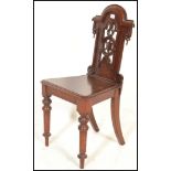 A 19th Century Victorian mahogany hall chair, with pierced back with scrolling decoration, raised on