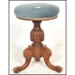 A Victorian 19th century mahogany revolving piano stool. Raised on a splayed leg base, with turned