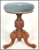 A Victorian 19th century mahogany revolving piano stool. Raised on a splayed leg base, with turned