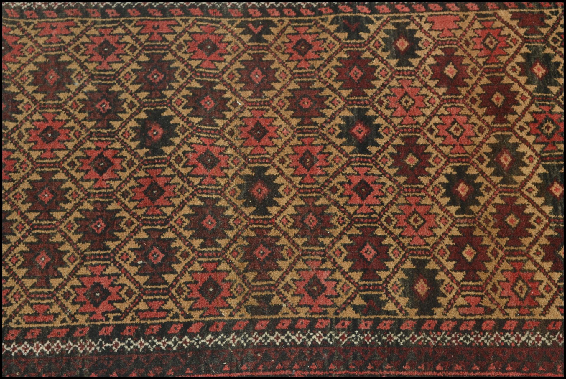 A 20th Century woolen hand knotted carpet floor rug on red ground, central geometric panel - Image 2 of 4