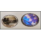 An early 20th Century silver brooch of oval form set with an iridescent butterfly wing panel