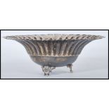 A silver 925 bon bon dish with scalloped edges being raised on a tripod leg base. Stamped 925 to