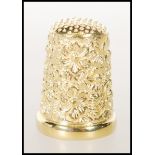 A stamped 925 sterling silver and gold plate thimble having floral decoration. Weighs 9.9g. Measures