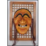 A 20th Century Japanese carved Kabuki / Noh style mask in the form of a stylised elongated face