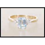 An English hallmarked 9ct gold ladies dress ring set with a rectangular blue topaz stone flanked