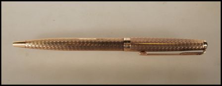 A vintage stamped 9ct gold Parker ballpoint writing pen having engine turned decoration having a