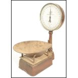 A set of early 20th Century Salter spring balance grocers scales, gilt finish with circular dial