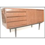 A mid century melamine sideboard credenza being raised on tapering legs with angled wide body