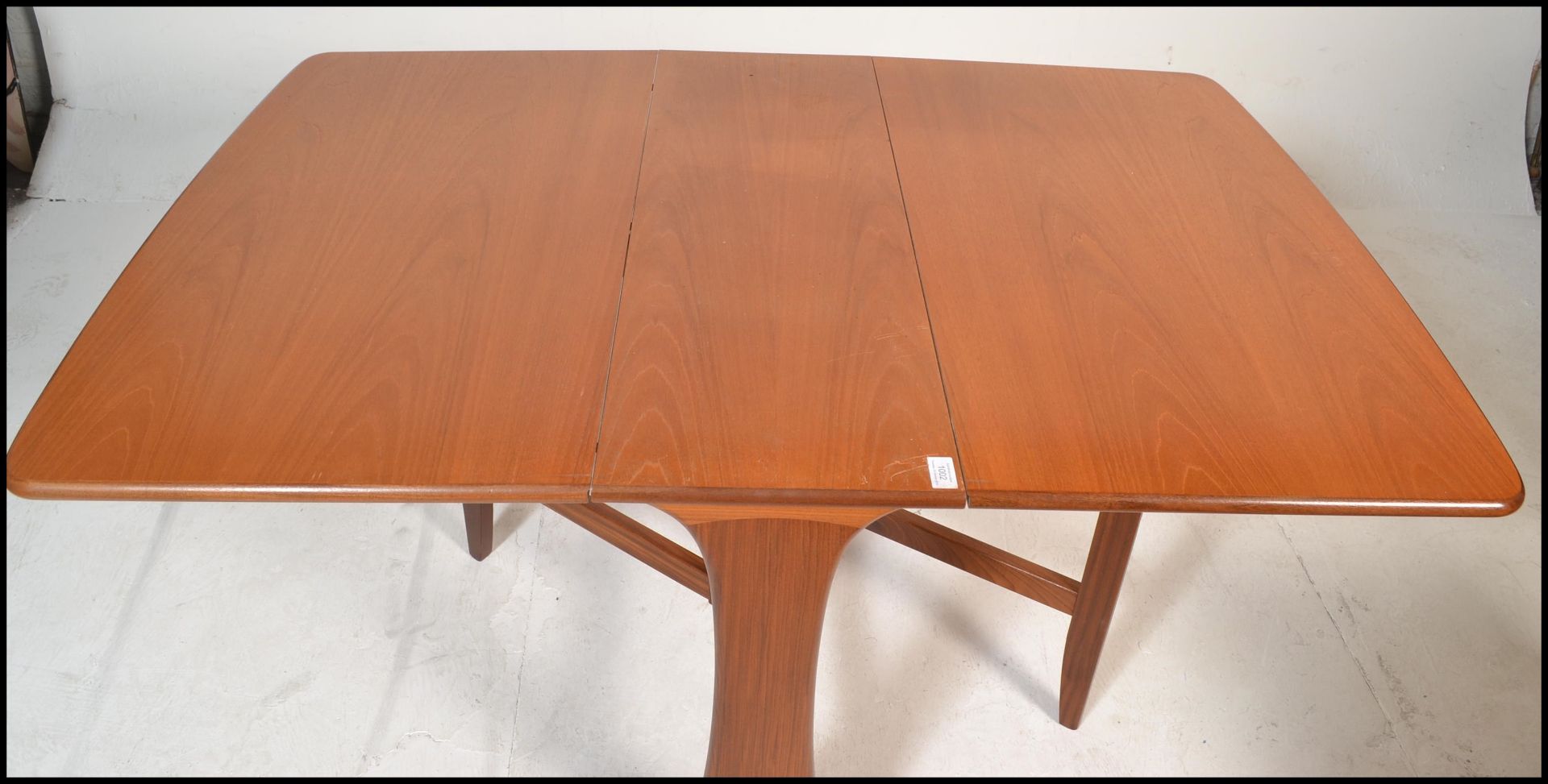 A 1970's teak wood Danish influenced G-Plan drop leaf dining table raised on shaped supports with - Bild 3 aus 5