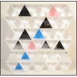 An unusual 20th Century wall shelving unit constructed from white plastic triangular shelves some