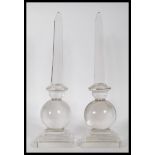 A pair of 20th Century glass obelisk centrepiece ornaments raised on square stepped bases with